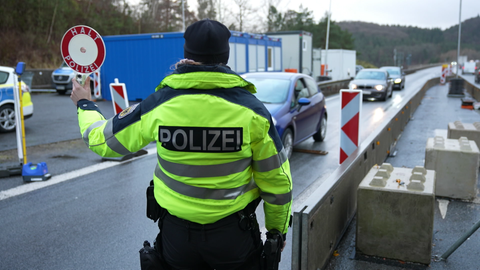 Ein Bundespolizist hält ein Auto an einem Grenzübergang an. Der Bundestag hat sich am Mittwoch für dauerhafte Grenzkontrollen ausgesprochen.