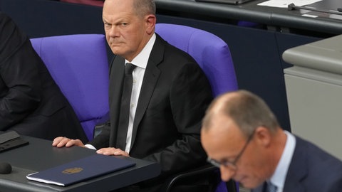 Bundeskanzle Olaf Scholz (SPD) (oben) und Friedrich Merz, CDU-Vorsitzender und Vorsitzender der CDUCSU-Bundestagsfraktion. Der Bundestag stimmt für Unionsantrag zur Migration