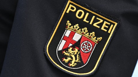 Das Logo der Polizei Rheinland-Pfalz auf einer Uniform (Symbolbild).