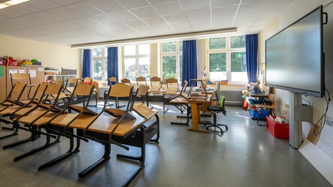 Ein leeres Klassenzimmer mit hoch gestellten Stühlen (Symbolbild). 