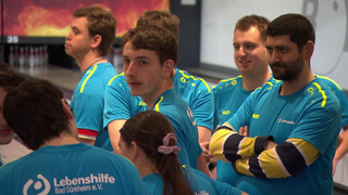 Menschen mit Behinderung spielen Bowling