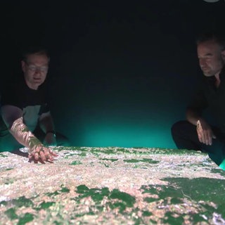 Zwei Männer zeigen auf eine digitale 3D-Landkarte