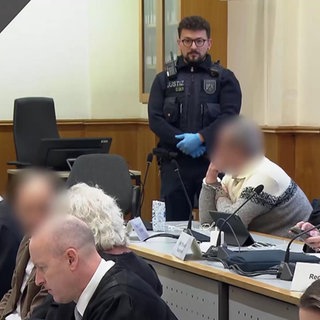 Mehrere Personen vor Gericht. Die Angeklagten sind unkenntlich gemacht.