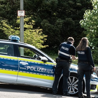 Die Polizei steht auf einer Straße in Rammelsbach. Ein Familienstreit hat einen mehrtägigen Polizeieinsatz ausgelöst. 