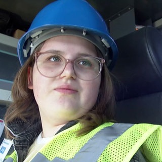 Junges Mädchen bedient einen Kran