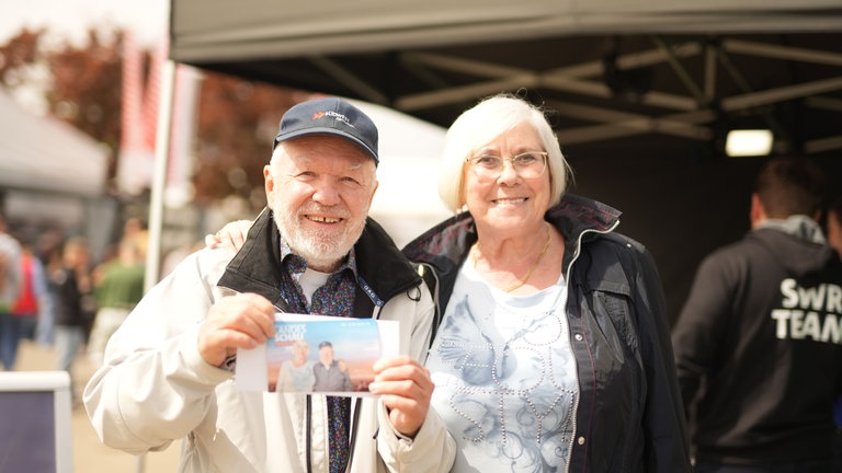 Ein Mann hält ein Foto in die Kamera. 