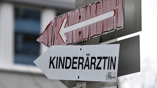 Ein Schild weist den Weg zu einer Arztpraxis