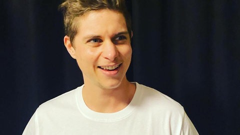 Vincent Maron im weißen T-Shirt. Er arbeitet im Queeren Zentrum Trier.