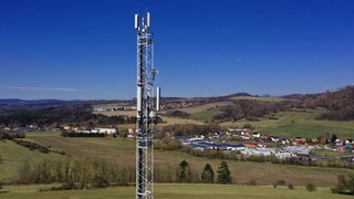 Ein Mobilfunkmast steht in ländlicher Umgebung. Obwohl vielerorts neue Mobilfunkmasten aufgestellt wurden, gibt es noch Funklöcher.