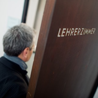 Ein Mann betritt das Lehrerzimmer. An rheinland-pfälzischen Grundschulen fehlen über 30 Schulleitungen.