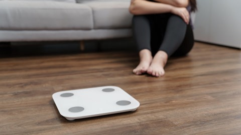 Eine Frau sitzt vor einer Waage. Die Fälle von Essstörungen haben laut Daten der KKH Kaufmännische Krankenkasse bei den 12- bis 17-jährigen Mädchen besonders stark zugenommen. Die Nutzung von Social Media könnte eine Rolle spielen. (Symbolbild)