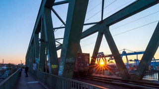 Kaiserbrücke in Mainz im Sonnenuntergang: Die Einigung im Zollstreit zwischen der Europäischen Union und den USA hat neben leichter Entspannung vor allem kritische Reaktionen in der Wirtschaft ausgelöst.