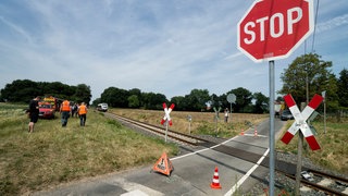 Rettungskräfte stehen am 21.06.2017 in Alpen (Nordrhein-Westfalen) an einem Unfallort. Ein 15-jähriger Junge ist auf einem unbeschrankten Bahnübergang im niederrheinischen Alpen vom Zug erfasst und getötet worden. 