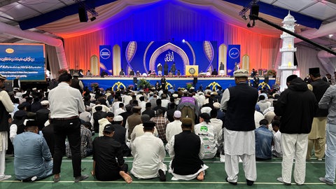 Im Zelt wird von mehreren Muslimen kniend gebetet. Mehrere zehntausend Mitglieder der Ahmadiyya-Gemeinde kommen auf dem Flugplatz Mendig zu ihrem jährlichen Treffen zusammen.