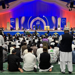 Im Zelt wird von mehreren Muslimen kniend gebetet. Mehrere zehntausend Mitglieder der Ahmadiyya-Gemeinde kommen auf dem Flugplatz Mendig zu ihrem jährlichen Treffen zusammen.