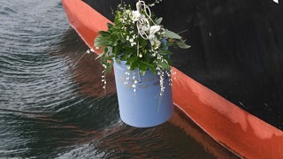 Eine Urne wird ins Wasser gelassen (Symbolbild) - Flussbestattungen sind ab Oktober in RLP möglich, der Landtag hat ein neues Gesetz verabschiedet.