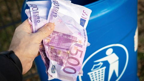Eine Person hält mehrere 500 Euro-Scheine in der Hand und ist im Begriff diese in einen Mülleimer zu werfen. Der Bund der Steuerzahler hat sein "Schwarzbuch" mit Fällen veröffentlicht, in denen seiner Ansicht nach Geld verschwendet wird.