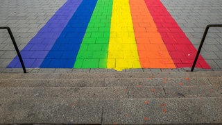 Regenbogensymbol vor Treppenstufen