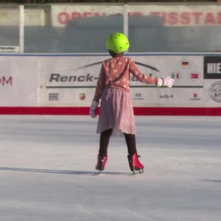 Ein Mädchen auf der Eislaufbahn