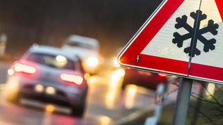 Ein Verkehersschild warnt Glätte auf der Straße. Am Montag könnte es im Berufsverkehr in Rheinland-Pfalz Glatteis geben.
