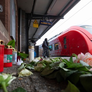 Kerzen und Blumen erinnern auf dem Bahnsteig am Bahnhof in Landstuhl an den getöteten Bahnmitarbeiter Serkan C. Der mutmaßliche Täter war offenbar bereits vor der Tat auffällig geworden.