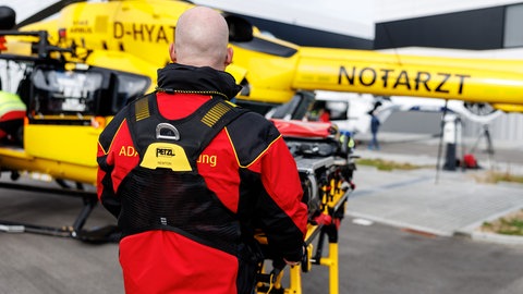 Ein Luftretter vom ADAC schiebt eine Trage zu einem Rettungshubschrauber (Übung) - ADAC veröffentlicht Jahresbilanz Einsätze