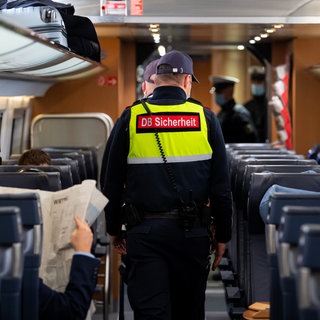 Bahnmitarbeiter geht durch ein Abteil - Diskussion um mehr Sicherheit für das Personal