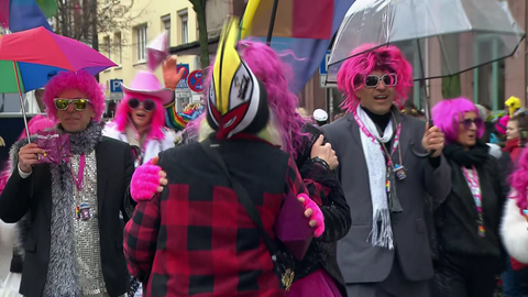 Regenschirme und Kopfbedeckungen sind beim Rosenmontagszug in Mainz äußerst brauchbare Utensilien. Das Wetter ist grau, ungemütlich und zeitweise nass. 
