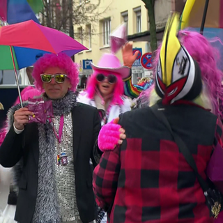 Regenschirme und Kopfbedeckungen sind beim Rosenmontagszug in Mainz äußerst brauchbare Utensilien. Das Wetter ist grau, ungemütlich und zeitweise nass. 