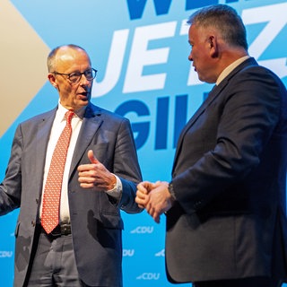 Bundeskanzler Merz (li) und CDU-Spitzenkandidat Gordon Schnieder beim Politischen Aschermittwoch in Trier. iOli