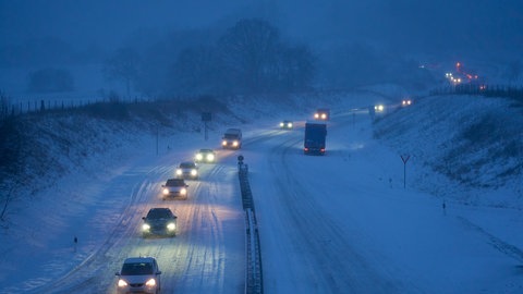 Fahrzeuge sind auf der verschneiten Bundesstraße B255 in Fahrtrichtung Rennerod unterwegs.