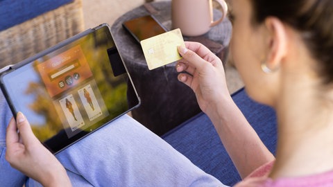 Eine Frau hält eine Kreditkarte in der Hand. Viele junge Menschen verschulden sich beim Online-Shopping (Symbolbild).