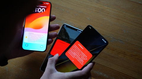 Mehrere Smartphones zeigen Warnmeldungen. Am 12. März war in Rheinland-Pfalz landesweiter Warntag (Symbolbild)
