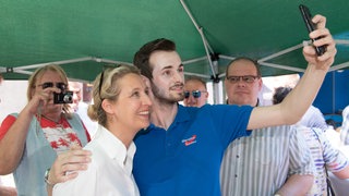 Alice Weidel, Fraktionsvorsitzende der AfD im Bundestag, posiert während einer Wahlkampfveranstaltung für ein Foto mit einem jungen AfD-Mitglied.