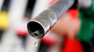 Benzin tropft aus einem Tankrüssel.