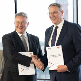 Gordon Schneider (CDU,l) und der scheidenden Ministerpräsident Alexander Schweitzer (SPD) präsentieren den gemeinsamen Koalitionsvertrag für die Regierung in Rheinland-Pfalz.
