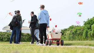 Mit Bollerwagen ist eine Gruppe junger Männer am Vatertag unterwegs (Archivbild).