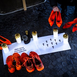 Kerzen, Kreuze und Schuhe in Orange - Erinnerung an die Opfer von Femiziden