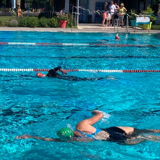 Schwimmerinn und Schwimmer im Becken vom Freibad Gimbsheim. Hier findet das 25-Stunden-Schwimmen statt. 