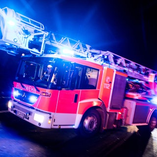Ein Feuerwehrauto fährt mit Blaulicht zu einem Einsatz. Starker Regen hat im Rhein-Lahn-Kreis für zahlreiche Feuerwehreinsätze gesorgt (Symbolbild).