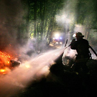 Ein Feuerwehrmann löscht einen Waldbrand. (Symbolbild)