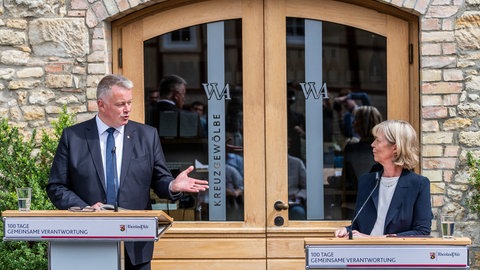 Gordon Schnieder (CDU), Ministerpräsident von Rheinland-Pfalz, und Doris Ahnen (SPD), Finanzministerin von Rheinland-Pfalz, stehen vor den Medienvertretern. Die CDU-geführte Landesregierung zog im Rahmen einer Pressekonferenz nach 100 Tagen Zwischenbilanz über ihre bisherige Arbeit.