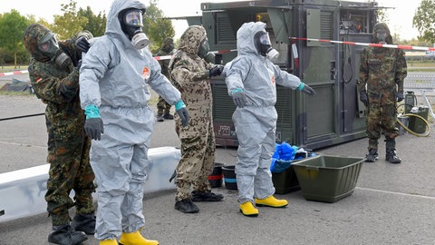 Soldaten des ABC-Abwehrregiments 750 "BADEN" dekontaminieren Mitarbeitende der BASF-Werkfeuerwehr im Anschluss an die Übung.