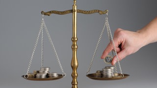 Kommunaler Entschuldungsfond im Stadtrat Kaiserslautern - auf einer Waage liegen Geldmünzen