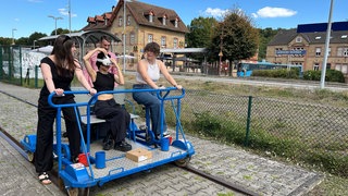 Drei Studentinnen der Hochschule Kaiserslautern testen ihr Projekt mit der VR-Brille.