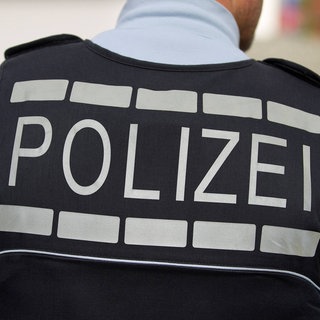 Polizist in Unfiform mit der Aufschrift "Polizei" auf der Weste