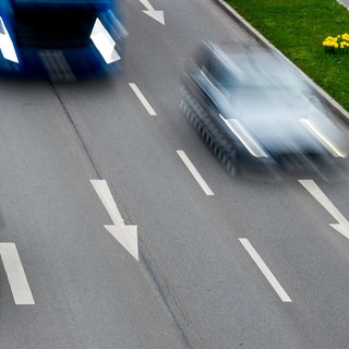 Zwei Autos und ein Lkw sind auf der Autobahn unterwegs.