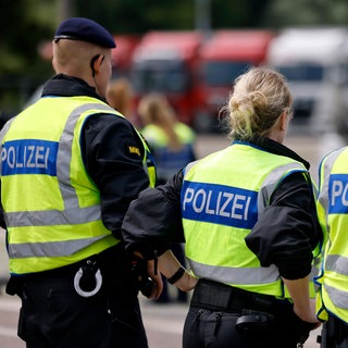 Polizisten stehen während einer Kontrolle auf einem Rastplatz. Am Wochenende stoppte die Polizei nach einer Schlägerei FCK-Fans auf dem Weg zum Spiel nach Berlin. 
