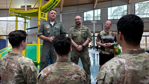 Drei Soldaten stehen vis a vis mit drei weiteren Soldaten in einer Schwimmhalle - in Ramstein haben Soldaten von US-Militär und Bundeswehr ein spezielles Sportabzeichen gemacht