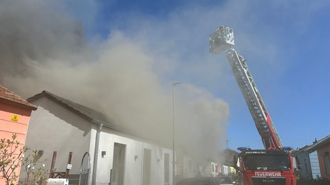 Feuerwehr mit Drehleiter über einem verqualmten Haus - Haus am Eselsbach in Kaiserslautern steht in Flammen